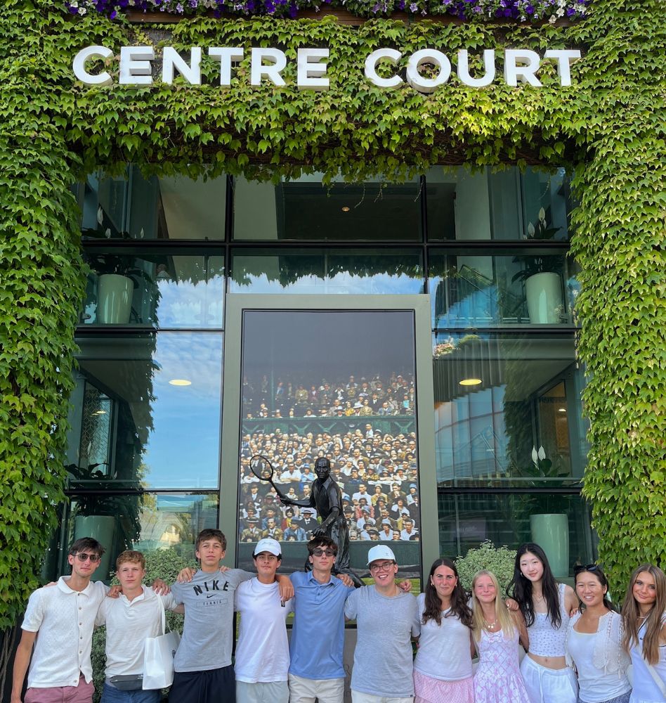 Group of teenagers posing for a photo at Wimbledon under a sign that says Centre Court