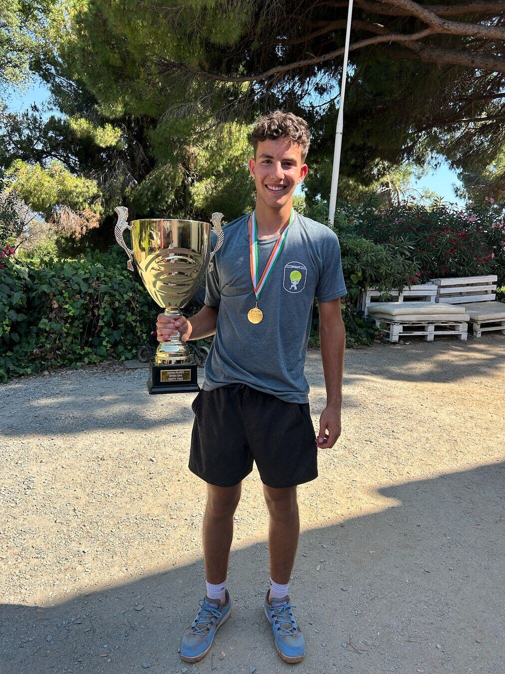 Junior Tennis Player holding a trophy after winning a tournament